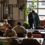 Team members working on laptops in a modern open-plan office