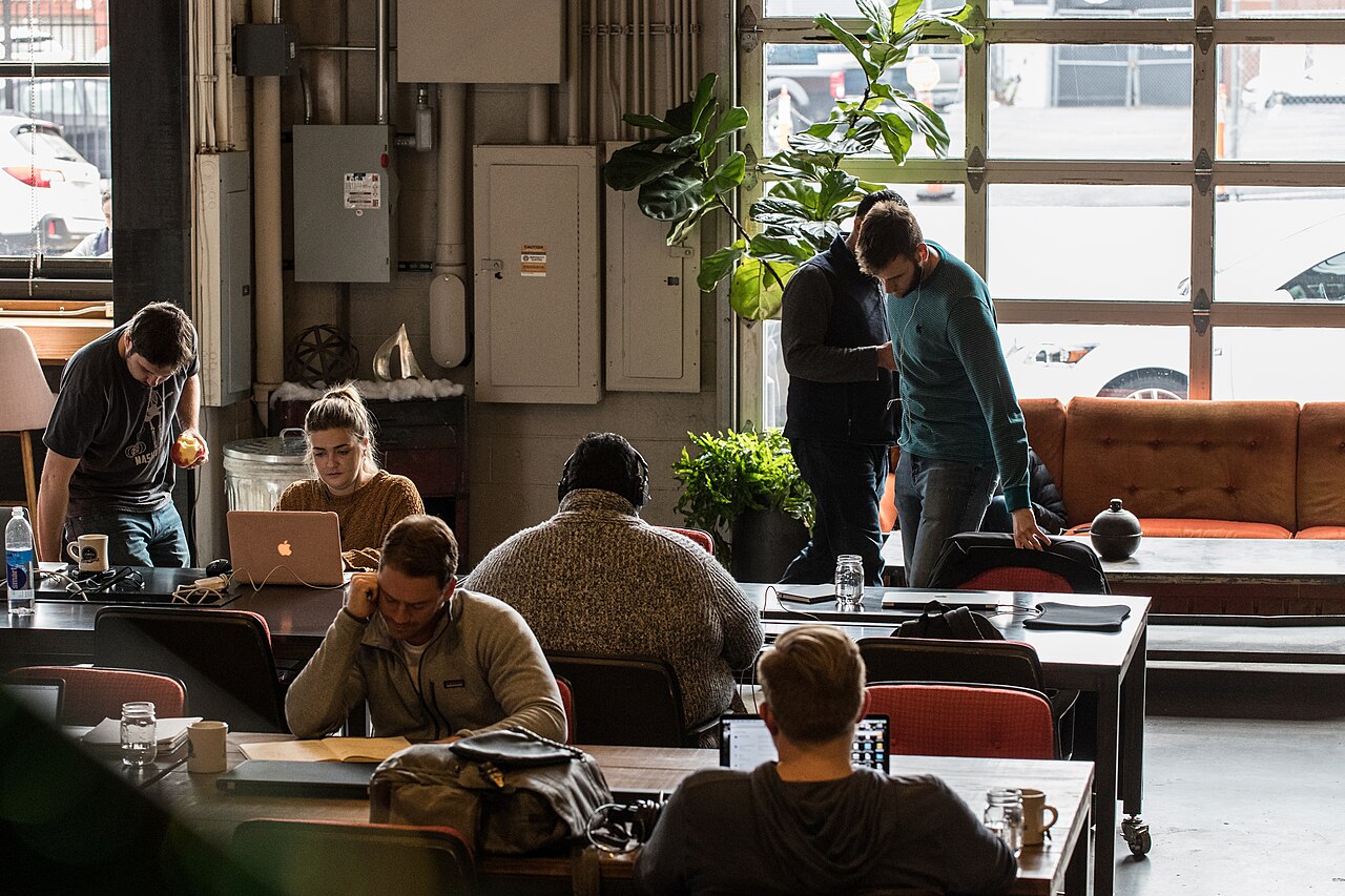 Team members working on laptops in a modern open-plan office