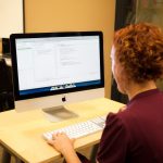 Programmer writing code on a desktop computer